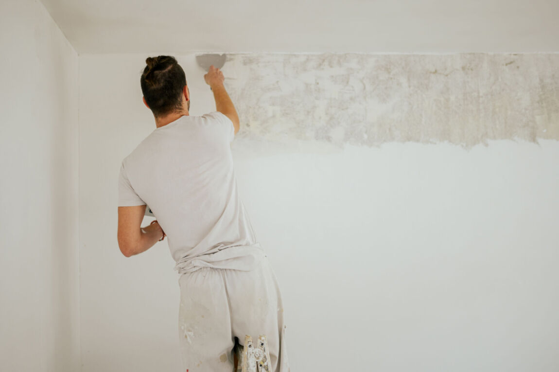 Skilled plasterer applying finishing coat